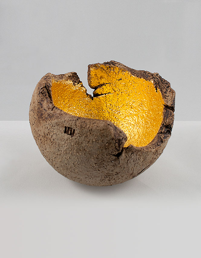 A ceramic bowl made using crank clay with manganese oxide staining to the outside and a 23ct gold leaf interior.